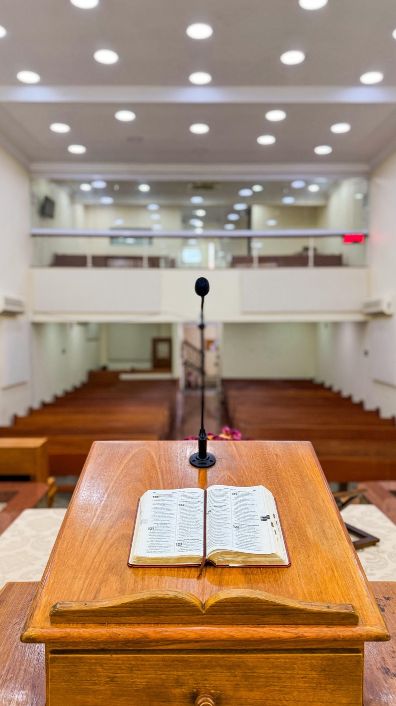 Púlpito com Bíblia aberta visto do salão da igreja